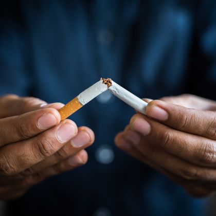 breaking a cigarette in half with someone's hands