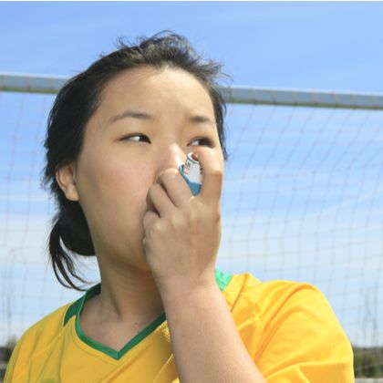 a soccer player using an inhaler for asthma relief
