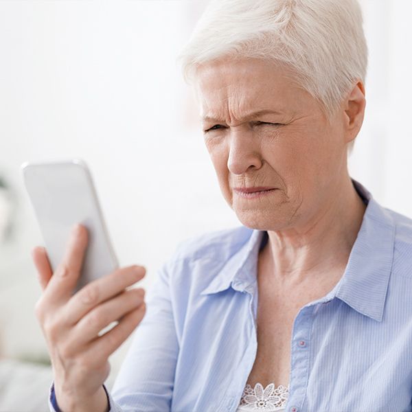 A woman squinting at her phone