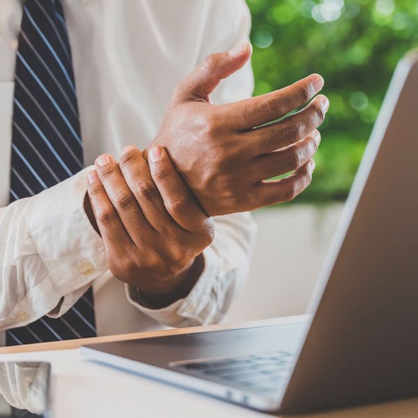 man in dress shirt holding wrist