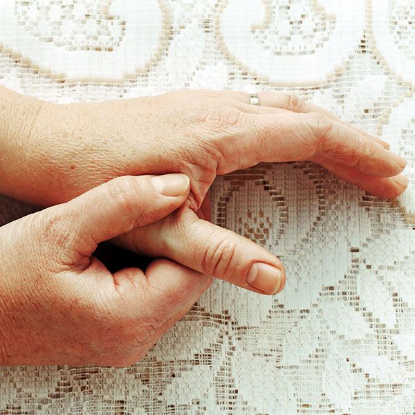 Mature person massaging area between thumb and index finger