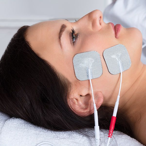 Woman with electrode patches applied to face