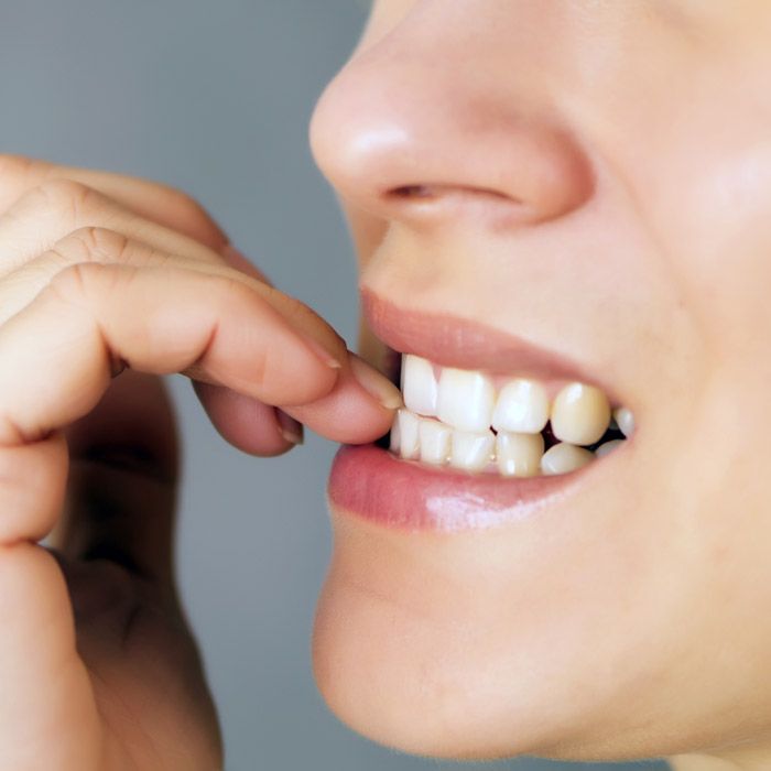 A woman biting her nails
