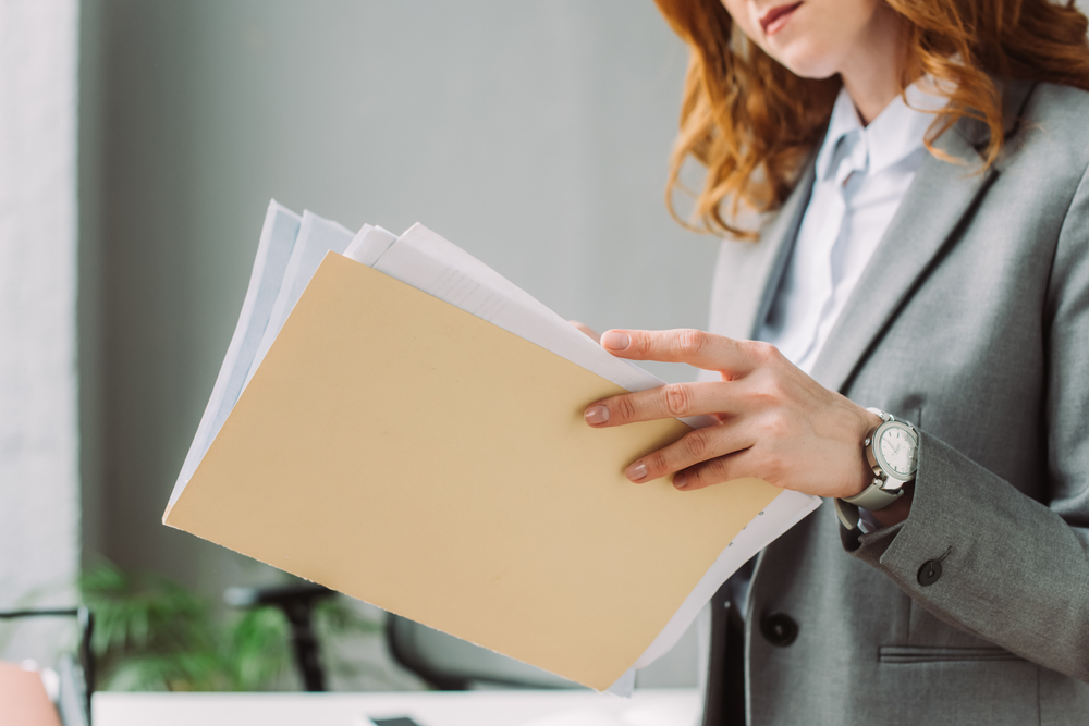 worker looking through documents in a file folder