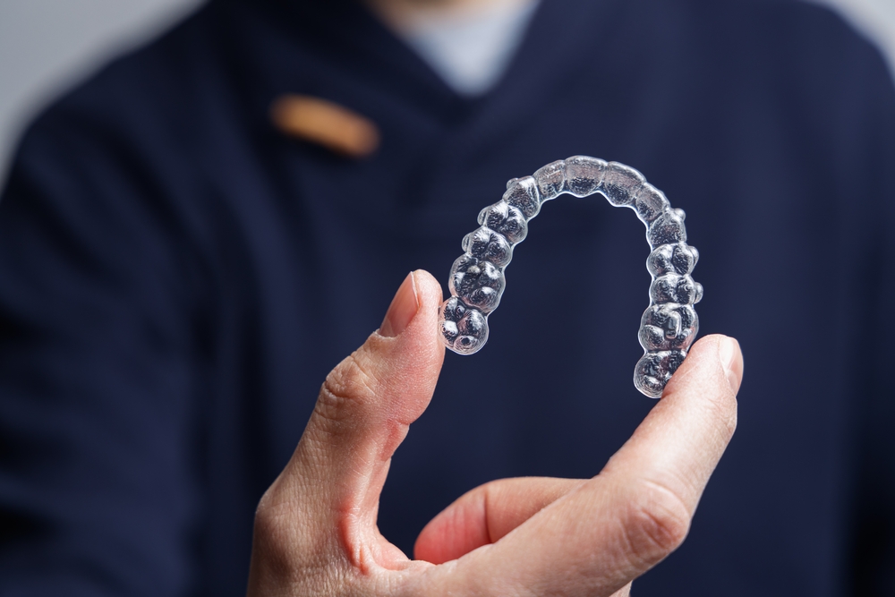 A person holding a clear orthodontic aligner tray