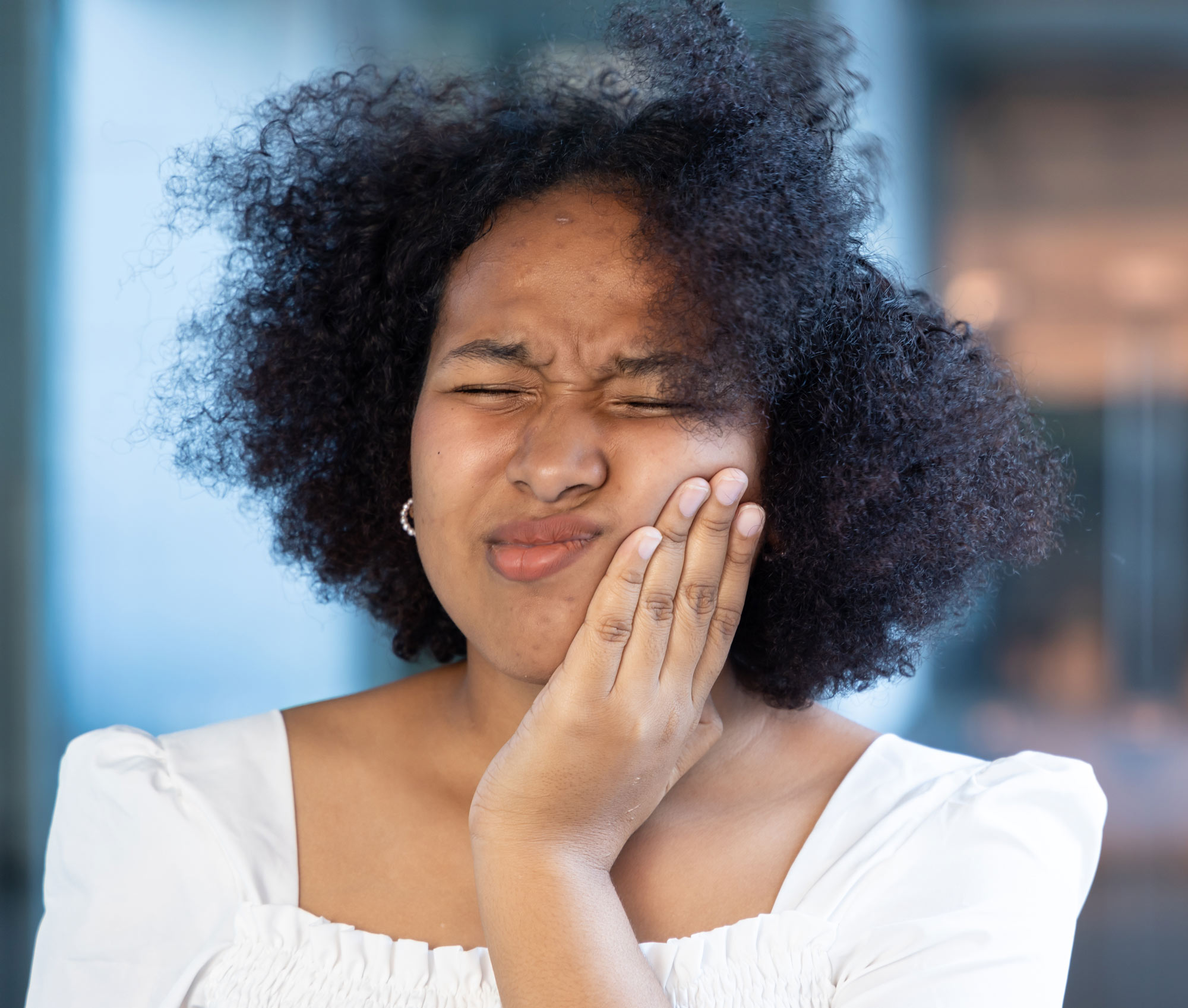 woman holding jaw in pain