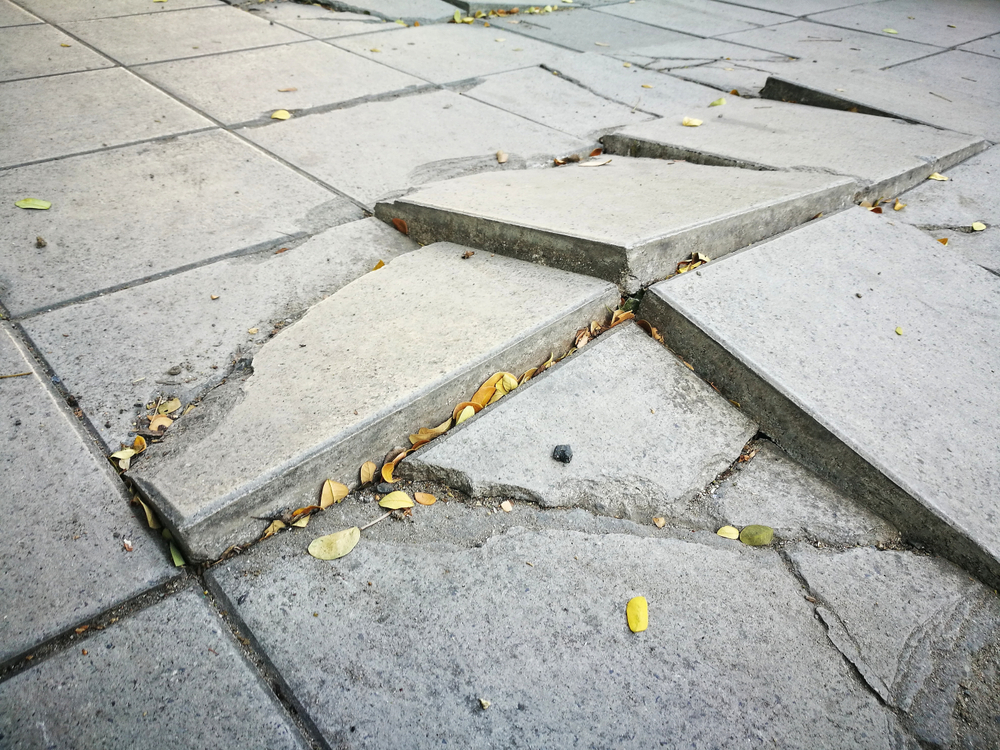 Broken sidewalk and pavers that pose an injury risk