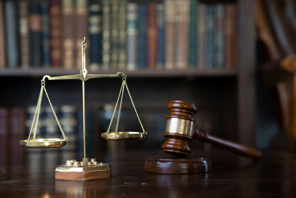 Scales and gavel on a table in front of law books