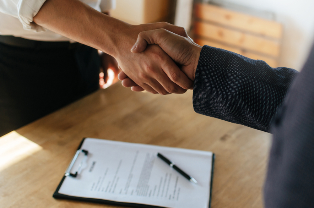 Lawyer and client shaking hands over a table
