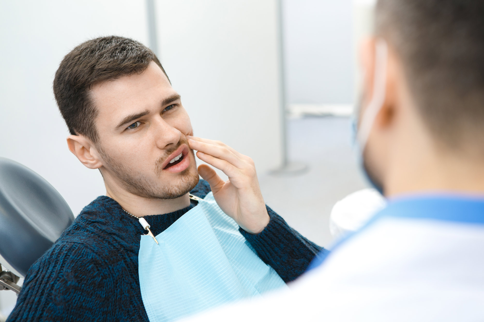 Man who needs to have a dental crown replaced meeting with a dentist