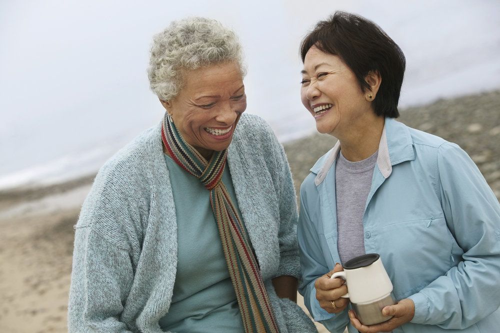Laughing woman with implant dentures talking to her friend