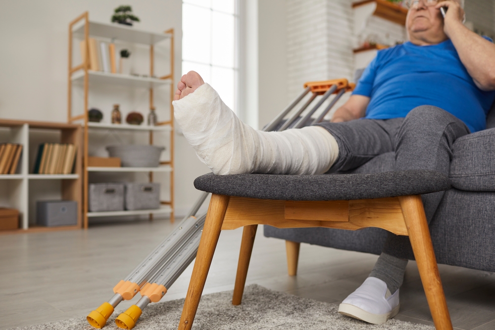 Injured man at home on couch speaking on the phone