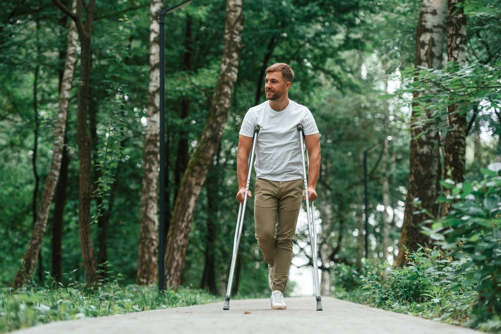 Man on crutches outdoors getting some fresh air