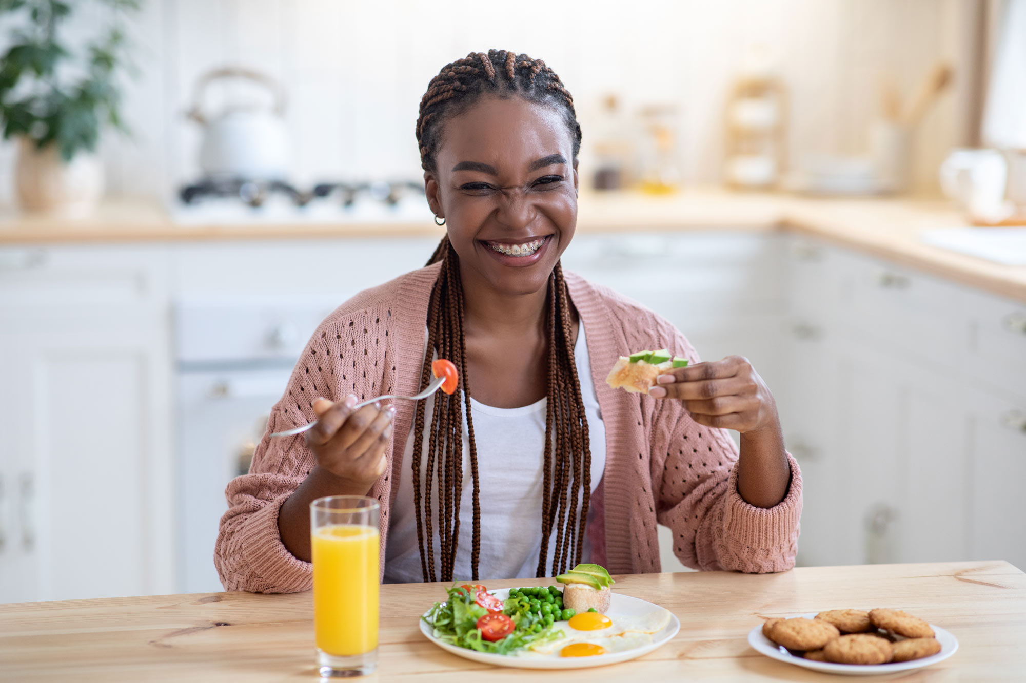 woman with braces smiling and enjoying a meal