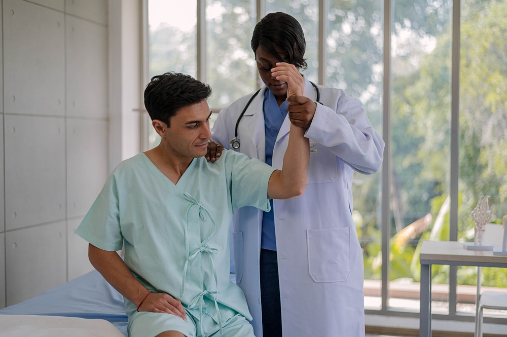 Patient with doctor rehabilitating his injured shoulder