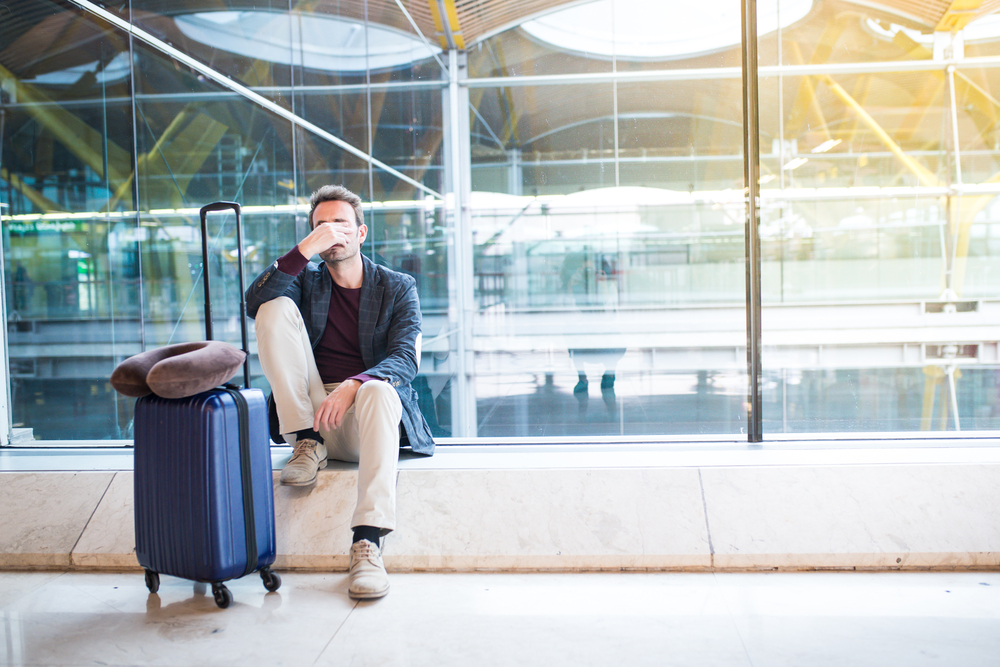 Exhausted man at airport after a long trip