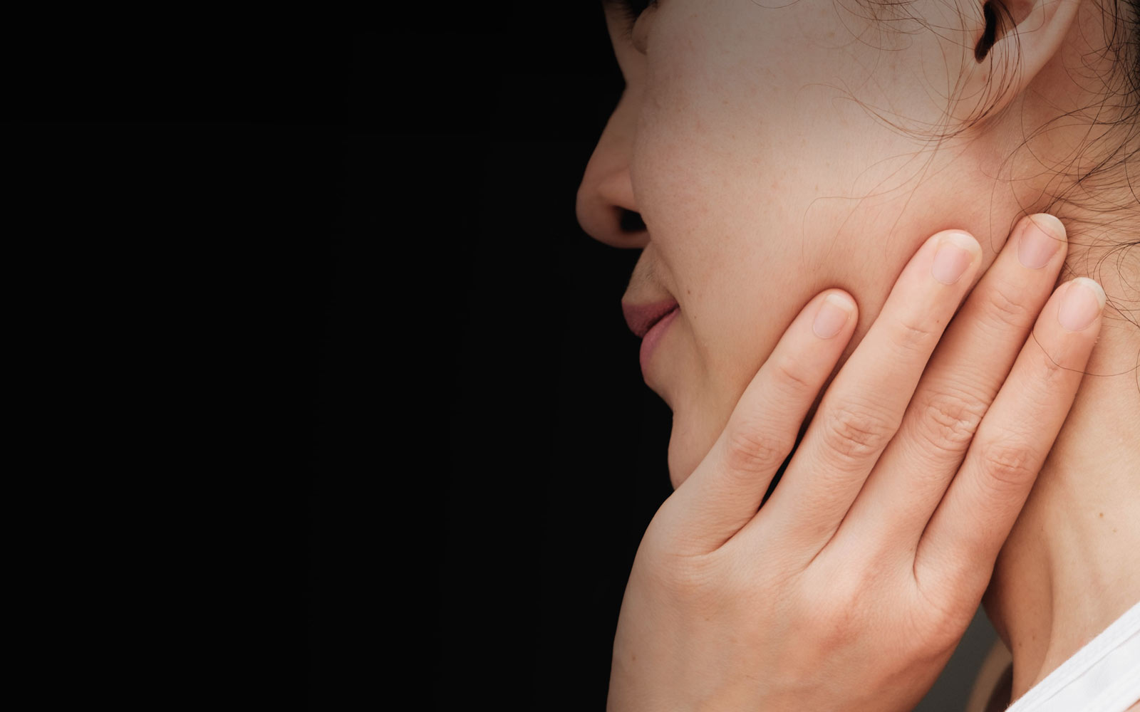woman holding jaw in pain