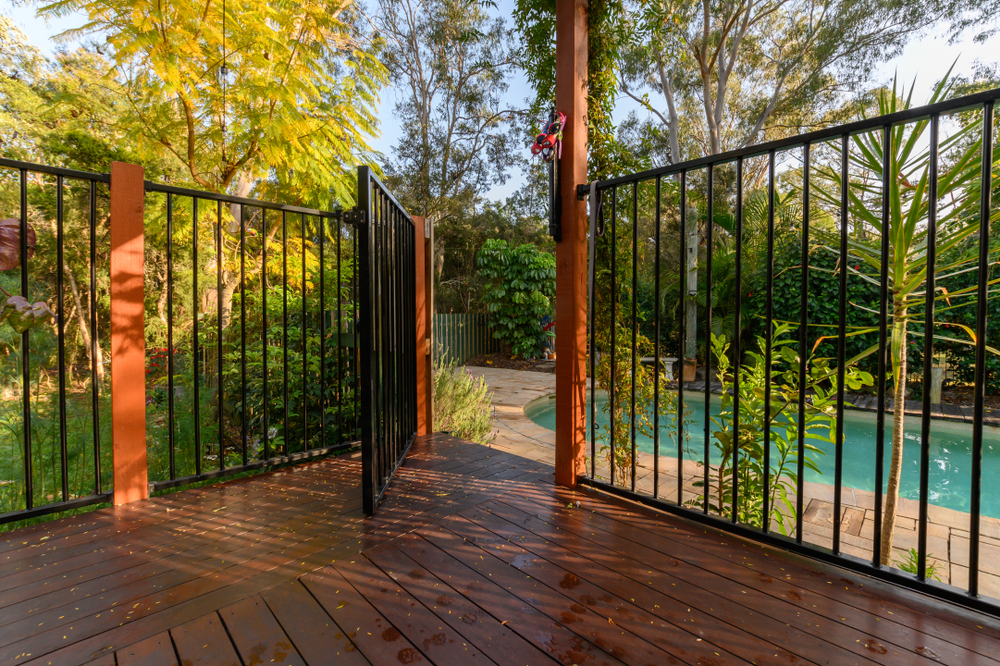 Gate with open door leading to a swimming pool