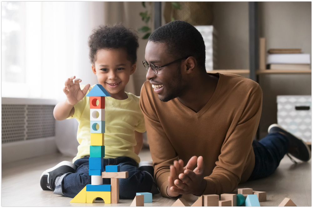 Smiling father and child playing with blocks