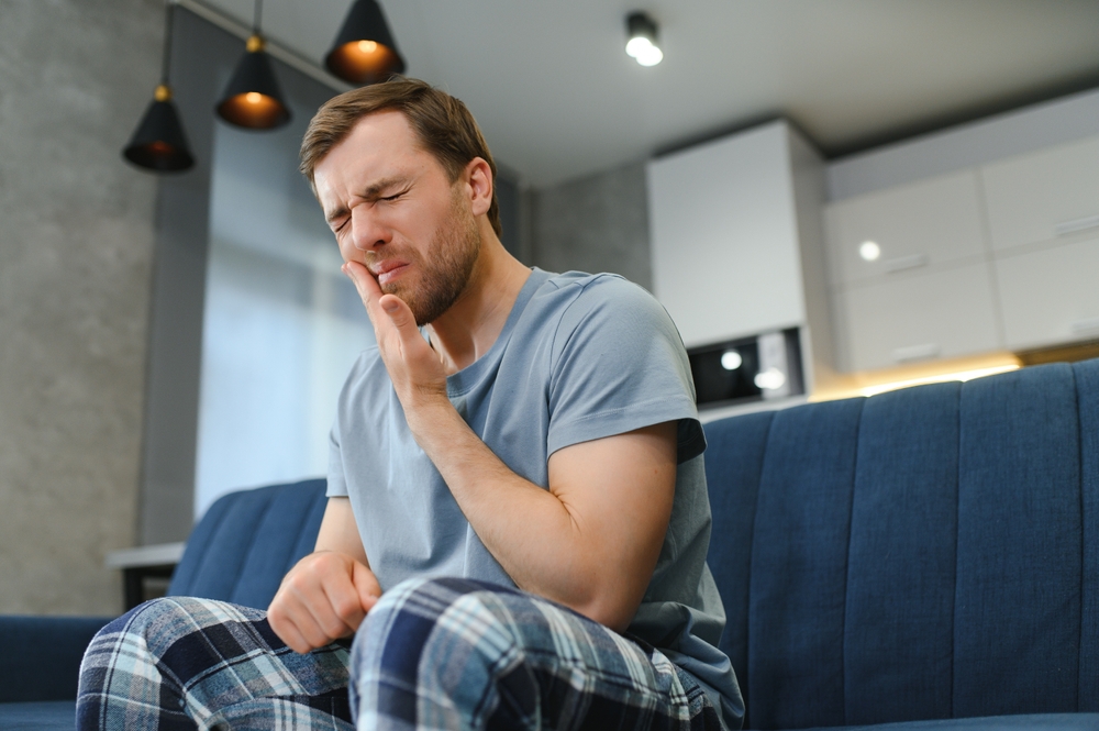Man with sore jaw in his living room