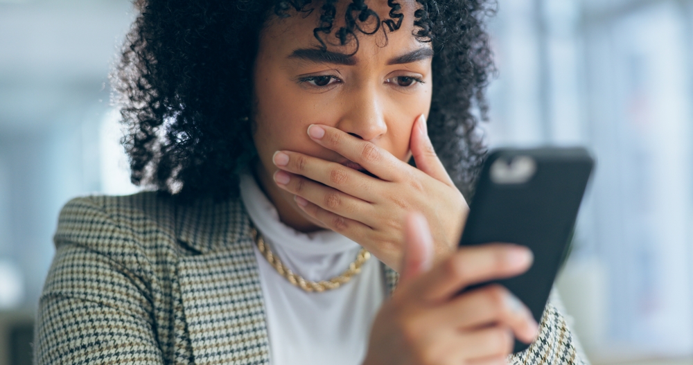 A woman reacting to an inappropriate message on her phone