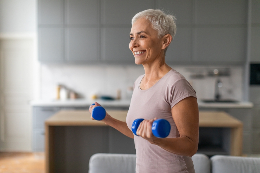 Older woman exercising with free weights at home