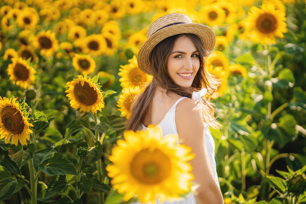 Woman walking through field of sunflowers