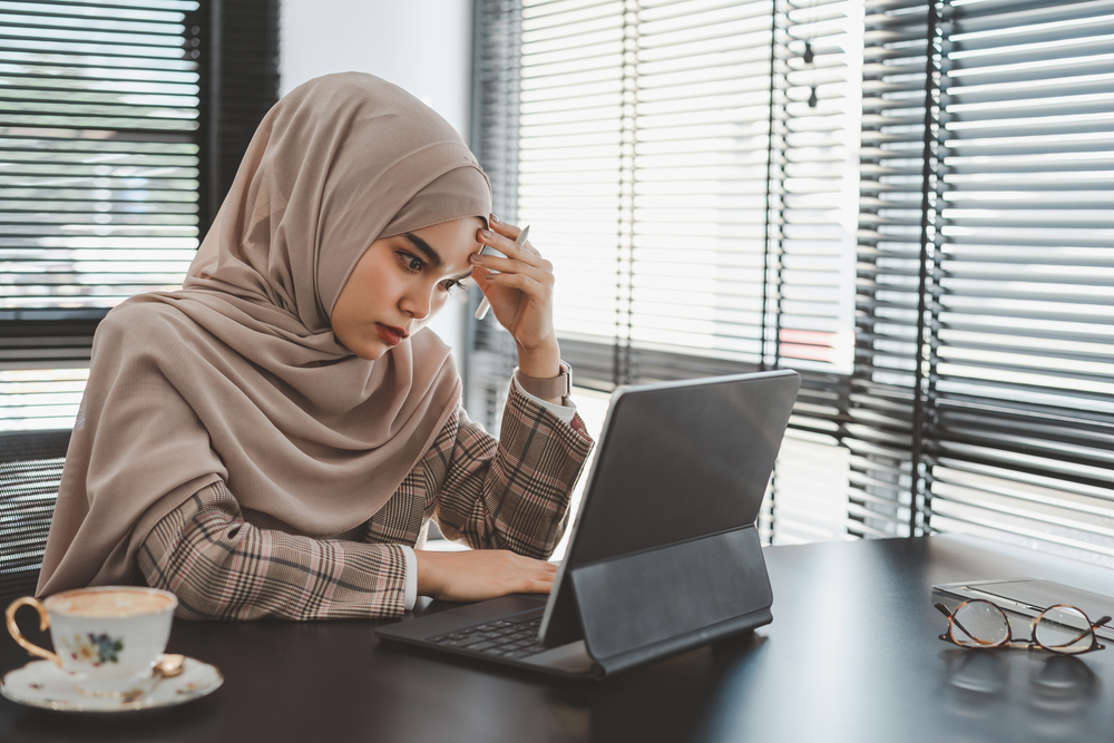 Muslim woman in a hijab feeling frustrated at work