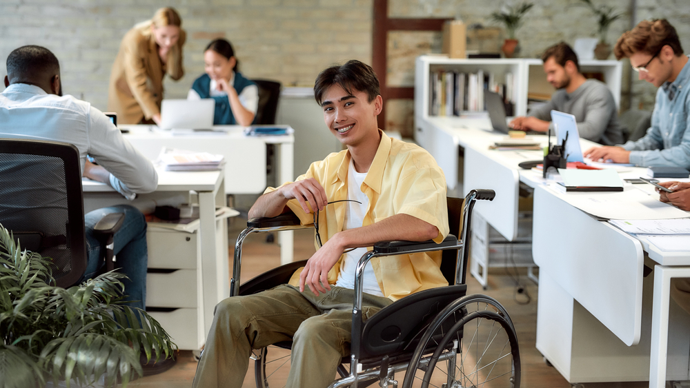 A young Asian man in a wheelchair at work