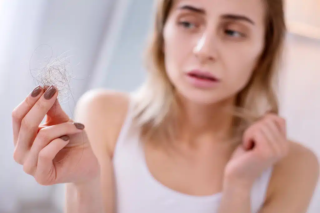 Woman holding fallen out hair