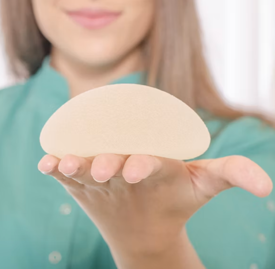 Woman holding a breast implant