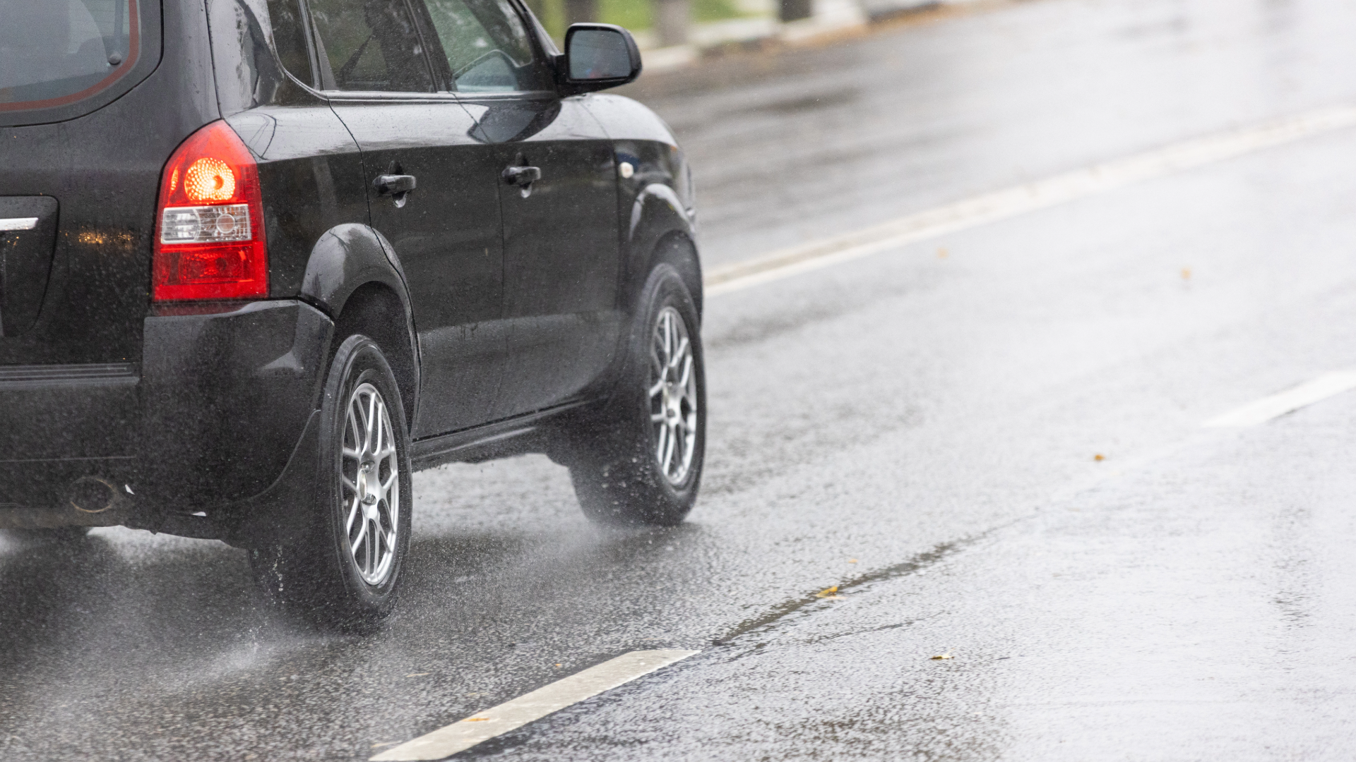 Vehicles traveling on a wet road during rain.