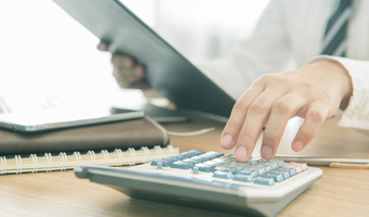 Woman using calculator istock