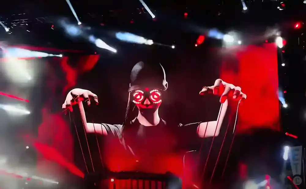 A person in a dark costume with glowing red skull makeup on their face, controlling puppet strings against a backdrop of red and white stage lights.