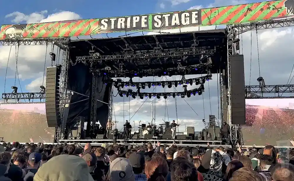 A band plays on a festival stage under a 