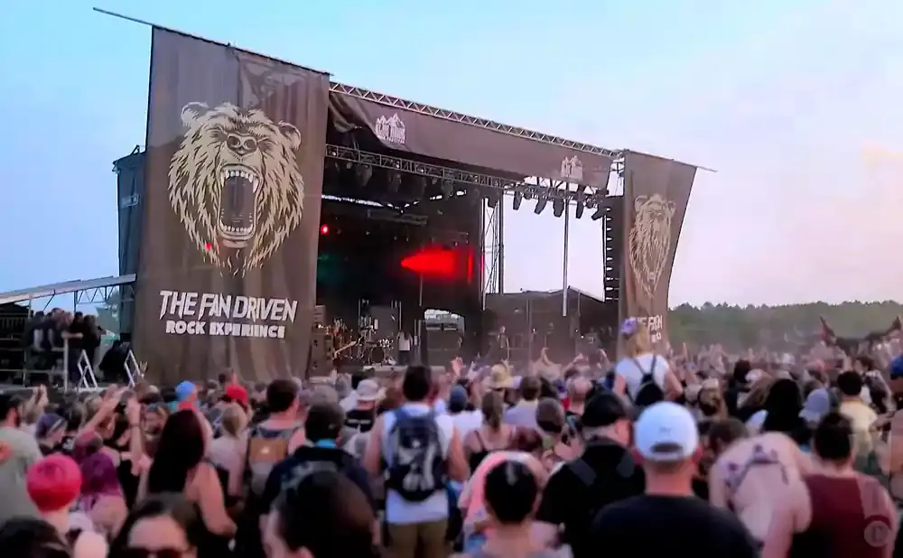 A rock concert stage with a large banner featuring a bear and the text 