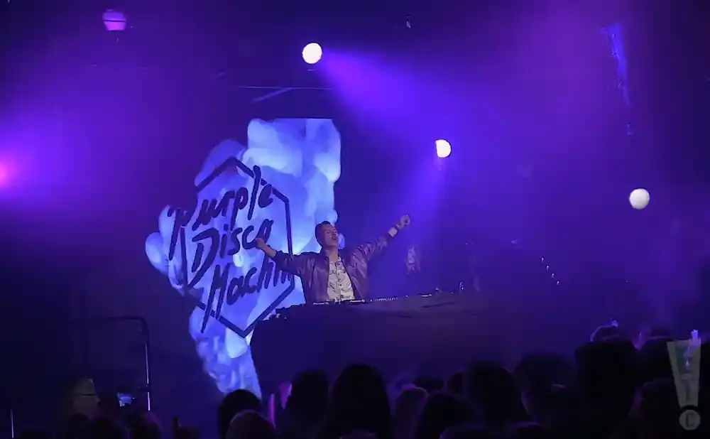 DJ performs on stage with a large 
