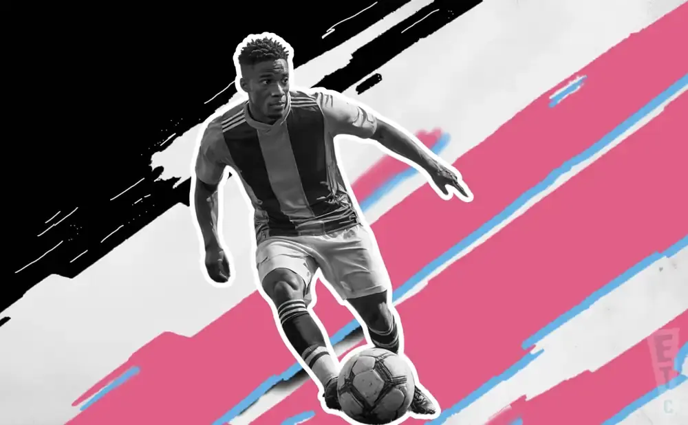A black and white soccer player dribbles a ball against a pink and white abstract background.