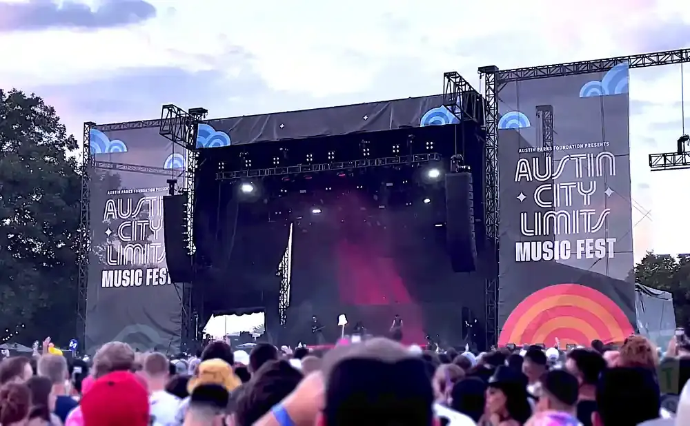 Austin City Limits Music Fest stage with large banners and a crowd of concertgoers.