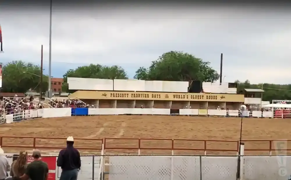 Rodeo arena with bleachers and a banner reading 