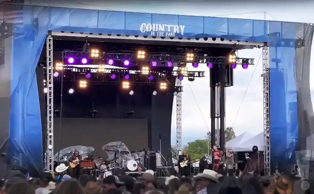 A band performs on an outdoor stage with 