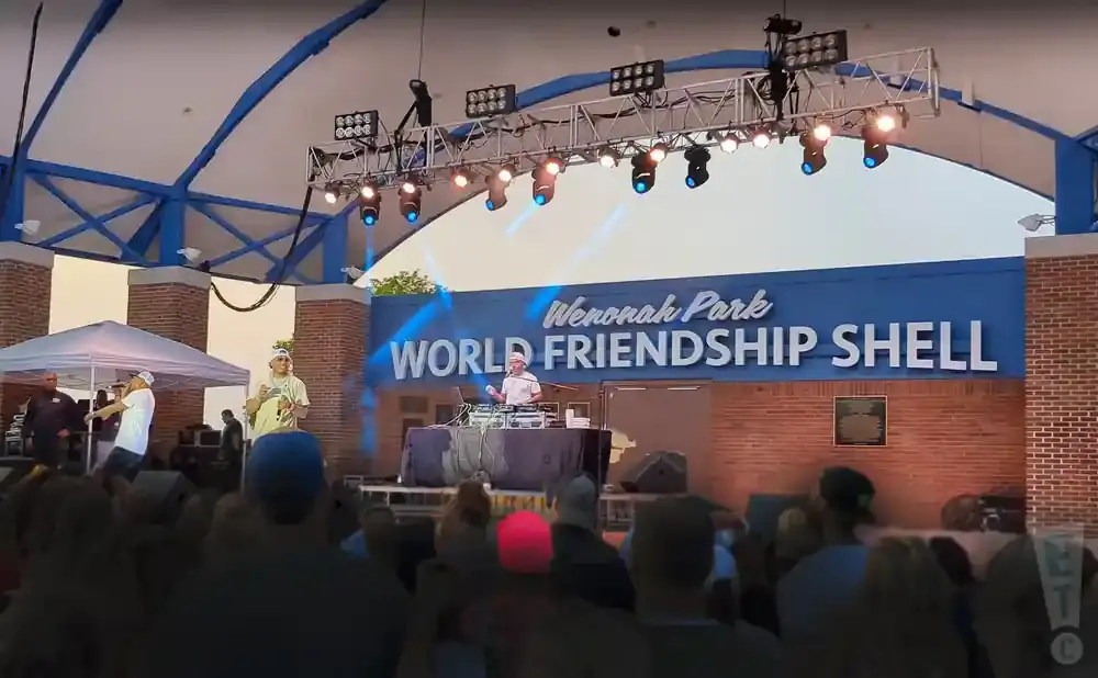 Rappers perform on stage at Wenonah Park World Friendship Shell as a DJ spins records.