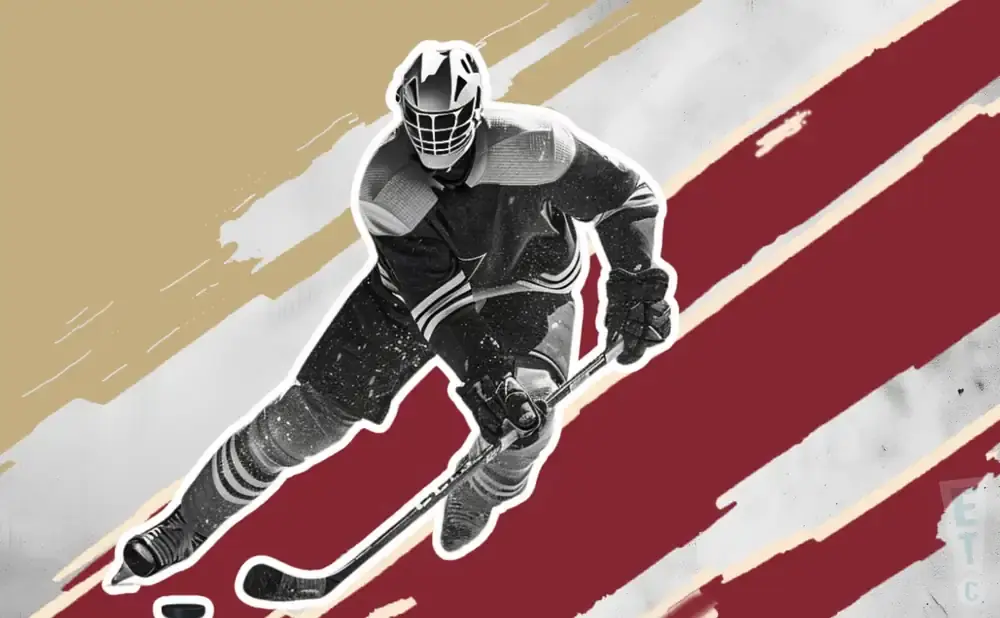 A hockey player in a mask and uniform skates with a stick.