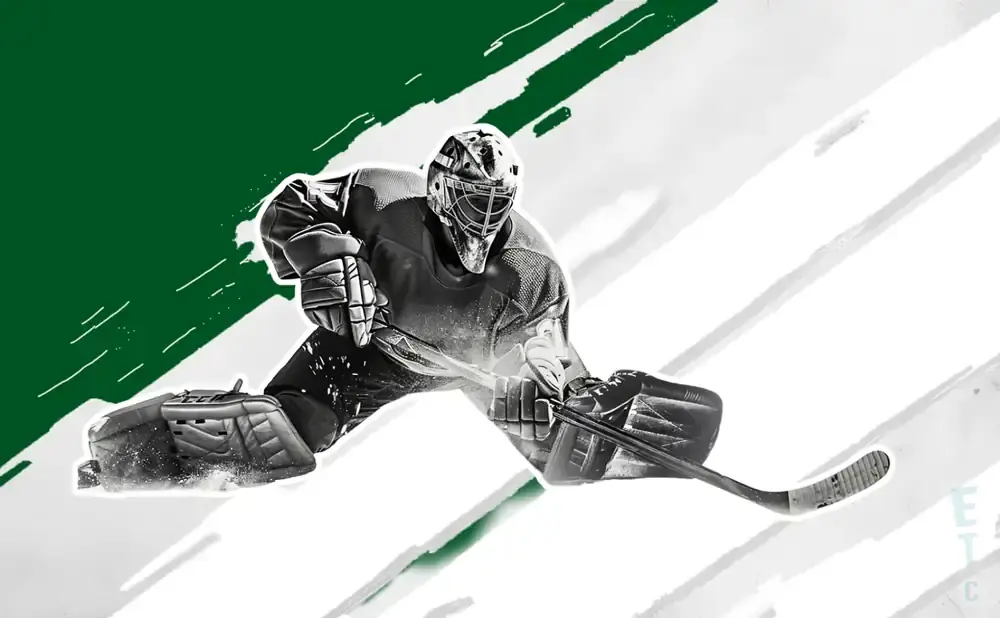 A hockey goalie in a crouched position ready to block a shot with their stick and pads.