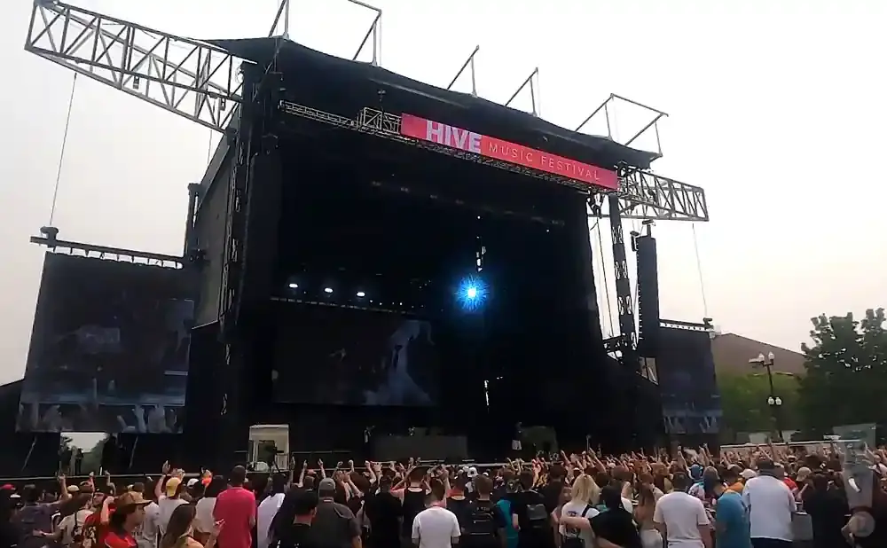 A large outdoor music festival stage with a banner reading 