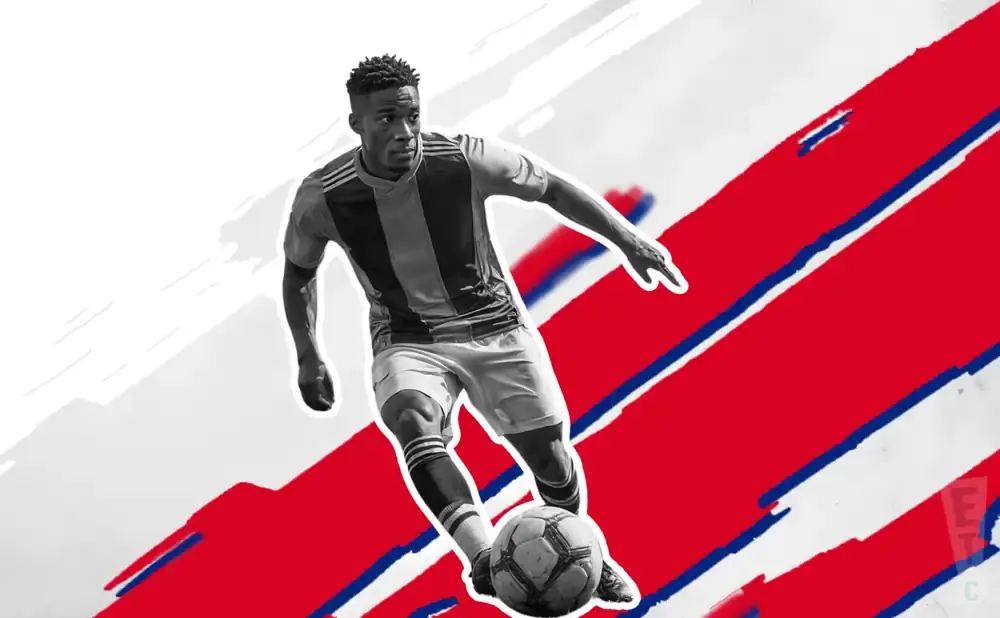 A soccer player in black and red jersey dribbles the ball against a red and white background with blue stripes.