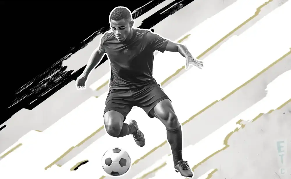 A black and white image of a soccer player in mid-air, dribbling a soccer ball.