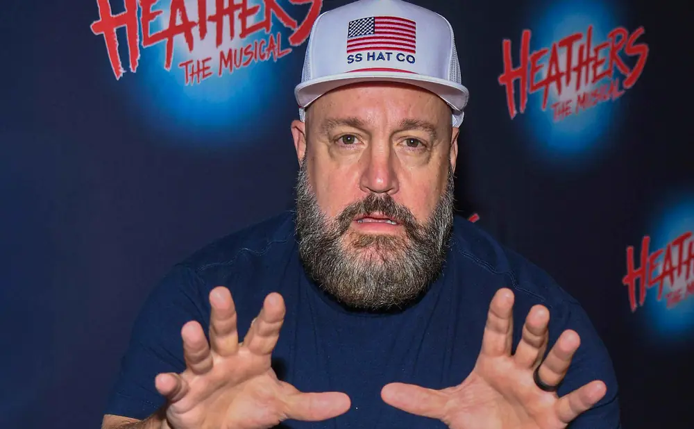 Man wearing a white trucker hat with the American flag and 