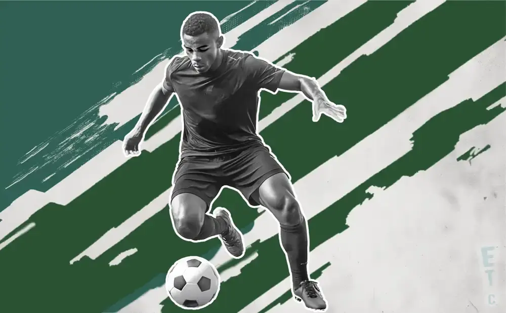 Soccer player in black uniform dribbling a ball, with green and white abstract brush strokes in the background.