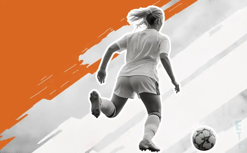 A female soccer player in a white jersey and shorts kicks a soccer ball.